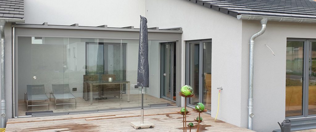 Regengeschützter Sommergarten mit Glasschiebewand